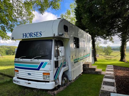 A horsebox parked on grass with steps leading up to it at Dobbin the horse box in The Lake District Cockermouth