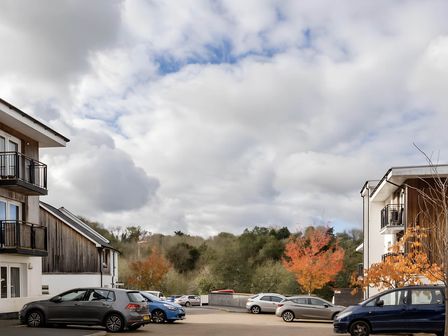 An outdoor view of buildings and parked cars at 2-Bed Apartment Sleeps 4 with Garden