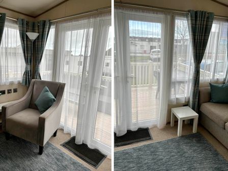 A living room with an armchair and sofa near sliding glass doors at Static Caravan Hoburne Devon Bay