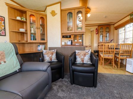 A living room with chairs and a dining table at Caravan at Argraig Llanrhyddlad near Cemaes Bay