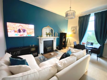 A living room with a sofa and television at 2A Redcliffe in Torquay