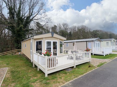 A caravan with a deck and seating area at 108 Fox Burrow Hang in Great Yarmouth