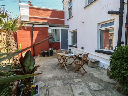 A garden with a table and chairs at Tipsy Turtle in Weymouth