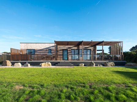 A house with wooden decking and glass doors at Barbara in Portreath