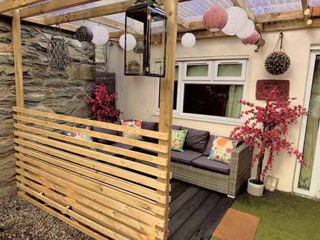 An outdoor seating area with a sofa and cushions at Zip Cottage Sleeps 2-3 climb snowdon zip world
