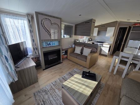 A living room with a television and fireplace at Beach holiday base with pool and kids activities