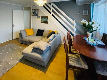 A living room with a sofa and dining table at tbc