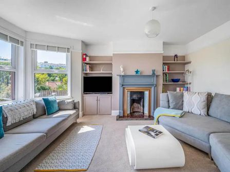 A living room with a television and bookshelves at tbc