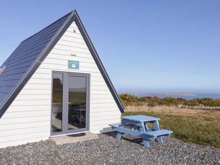 A cabin with a picnic table outside at Cabin 3 Cnoc na Naomh in Gortahawk