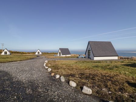 A view of several houses on a grassy area near the sea at Cabin 9 Inish Beag, Gortahawk