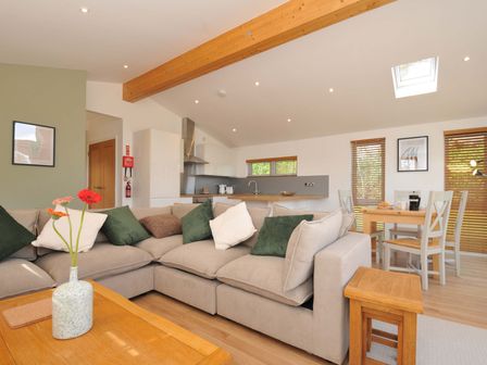 A living room with a sofa and dining area at 3 Faraway Fields in Dobwalls