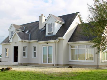 A house with multiple windows and a door at Welcome to the wild Atlantic way in Mulroy Bay