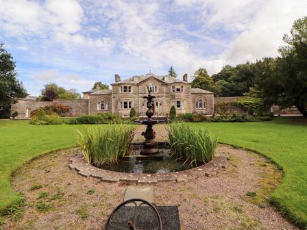 A garden with a fountain and a large building at Rochester Apartment in Orton