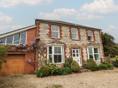 A house with a garage and plants in front at Millmead House Annex Portesham