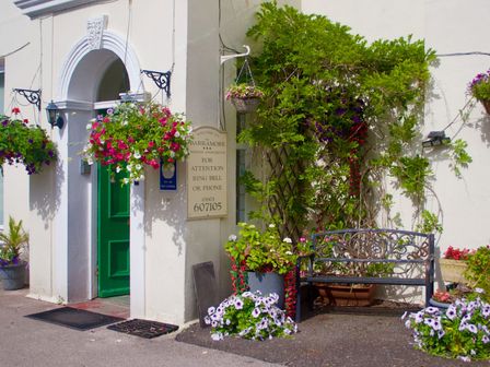 An entrance with flowers and a bench at Barramore in Torquay