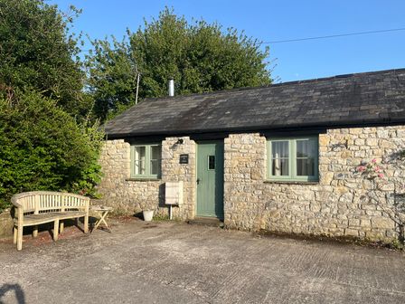 A cottage with a door and windows near a pathway at Warbler Cottage near Cowbridge