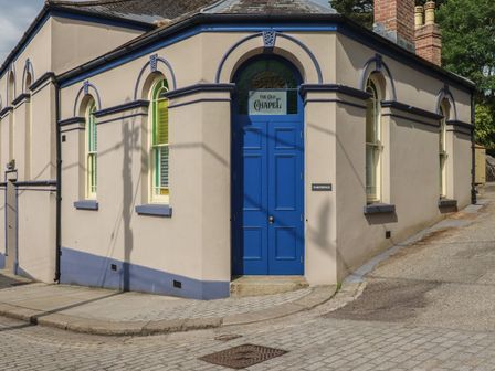 An exterior view of a building with a blue door and windows at Farthings, The Old Chapel in St. Austell