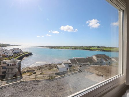 A view of water and houses from a window at Seaview in Y Felinheli