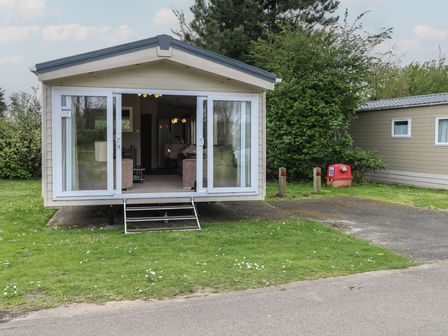 A mobile home with steps and windows at The Norfolk Nook 18 Castle Walk Burgh Castle