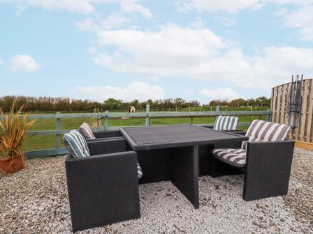 An outdoor seating area with a table and chairs at Moorland View Belowda near Roche