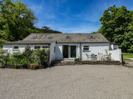 A cottage with a table and chairs at Daffodil Cottage in Blaencwm near Treorchy
