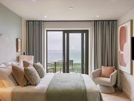 A bedroom with a bed and view of the ocean at tbc St. Ives