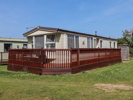 A caravan with decking and steps at Beech Lodge in Wadebridge