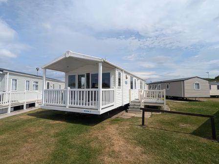 A mobile home with a deck and steps at 025 Maes Glas Prestatyn