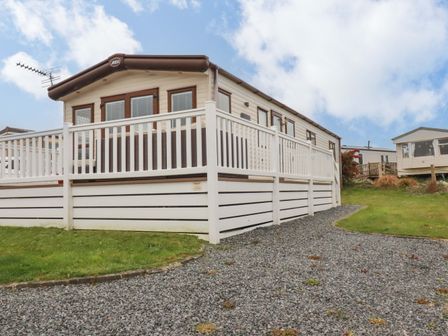 A caravan with a veranda on a gravel path at CC2