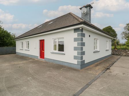 A house with a red door and windows at River House in