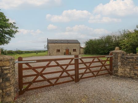 A house with a gravel driveway and gate at The Gallops in Barry