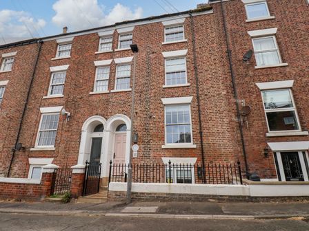 A facade of a brick building with windows and a door at Apartment Pink in Whitby