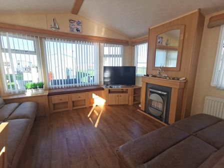 A living room with a television and sofa at Sea and Mountain view Sunbeach Holiday Snowdonia in Llwyngwril