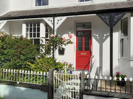 A doorway with red door and plants at Llys Awen in Llanwnda