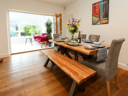 A dining room with a wooden table and benches at 29 Bincleaves Road, Weymouth