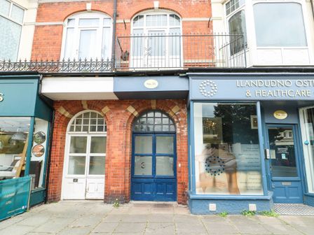 A building facade with doors and sign at Flat 3 in Llandudno