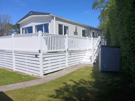 A mobile home with a deck and garden at Porthcurno 5, Perranwell near Goonhavern