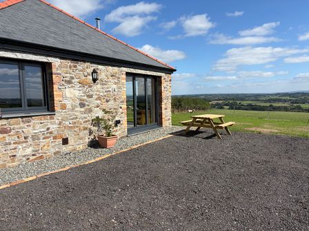 An outdoor area with a stone wall and picnic table at High View Barn in Launceston