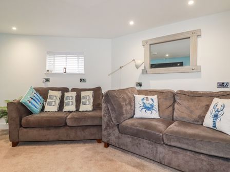 A living room with sofas and a window at 31 Tregoney Hill in Mevagissey