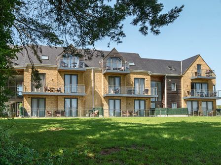 A building with balconies and grass area at Cotswolds Apartments 2B/S4 Chipping Norton