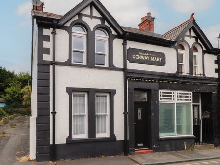 A building with a sign that reads Conway Mart at Conway Mart Cottage in Conwy
