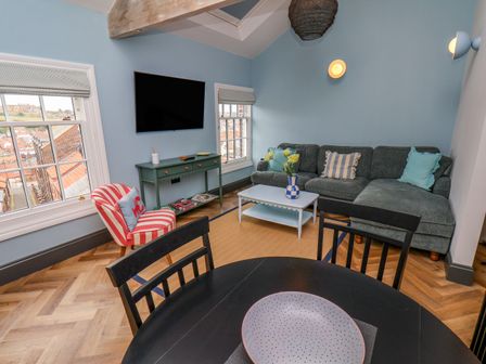 A living room with a sofa and television at Apartment Blue in Whitby