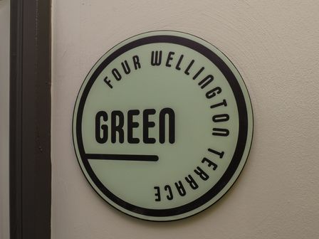 A sign displaying Four Wellington Terrace Green