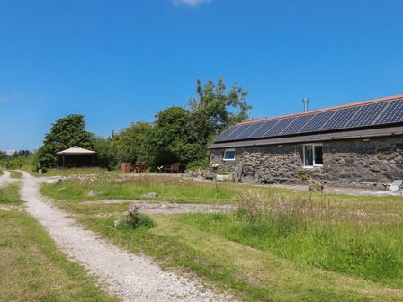 An outdoor view featuring a stone building and pathway at Moorland Retreat Bodmin