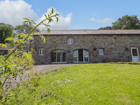 A stone house with grass area at The Cart House in Pontsian