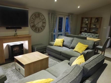 A living room with a sofa and television at Cayton Bay Lodge Parkdean Resorts, Scarborough