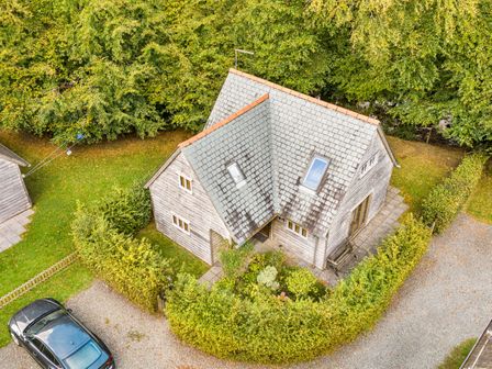 An aerial view of a house with a driveway and garden at Cabin Sleeps 6 with Parking and Patio, Tremail near Camelford