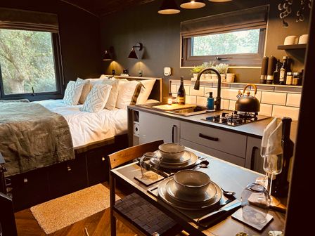 A bedroom with a kitchen area and dining table at The Old Barn in Newton Abbot
