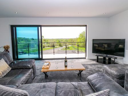 A living room with a sofa and television at Sycamore Cottage Frizington