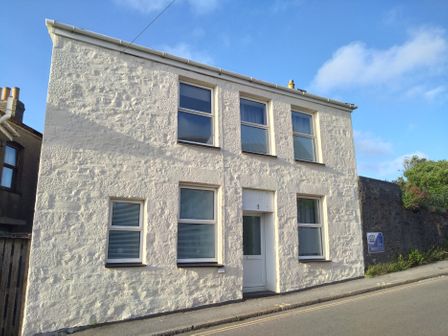 A white building with multiple windows in Redruth